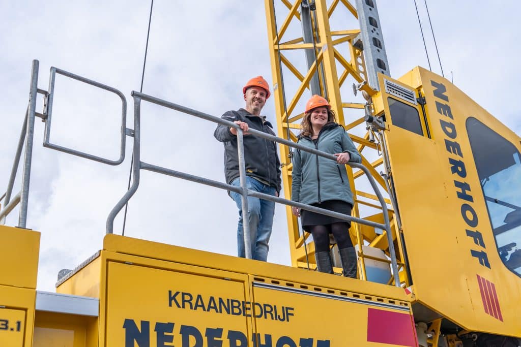 Wethouder Femke Vleij en een vertegenwoordiger van Vink Ontwikkeling staan op een bouwkraan.