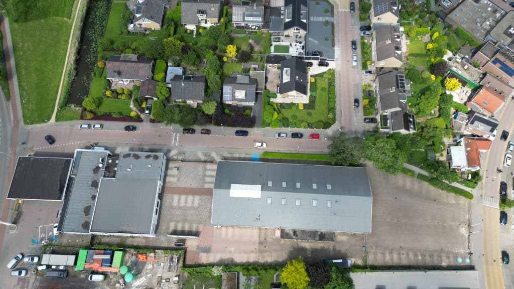 Een luchtfoto van het garagebedrijf bij het tankstation. Waarbij je de Souburghlaan en de Juliana van Stolberglaan ziet. Met in het midden de twee gebouwen van het garagebedrijf. Ernaast zit het parkeerterrein. 