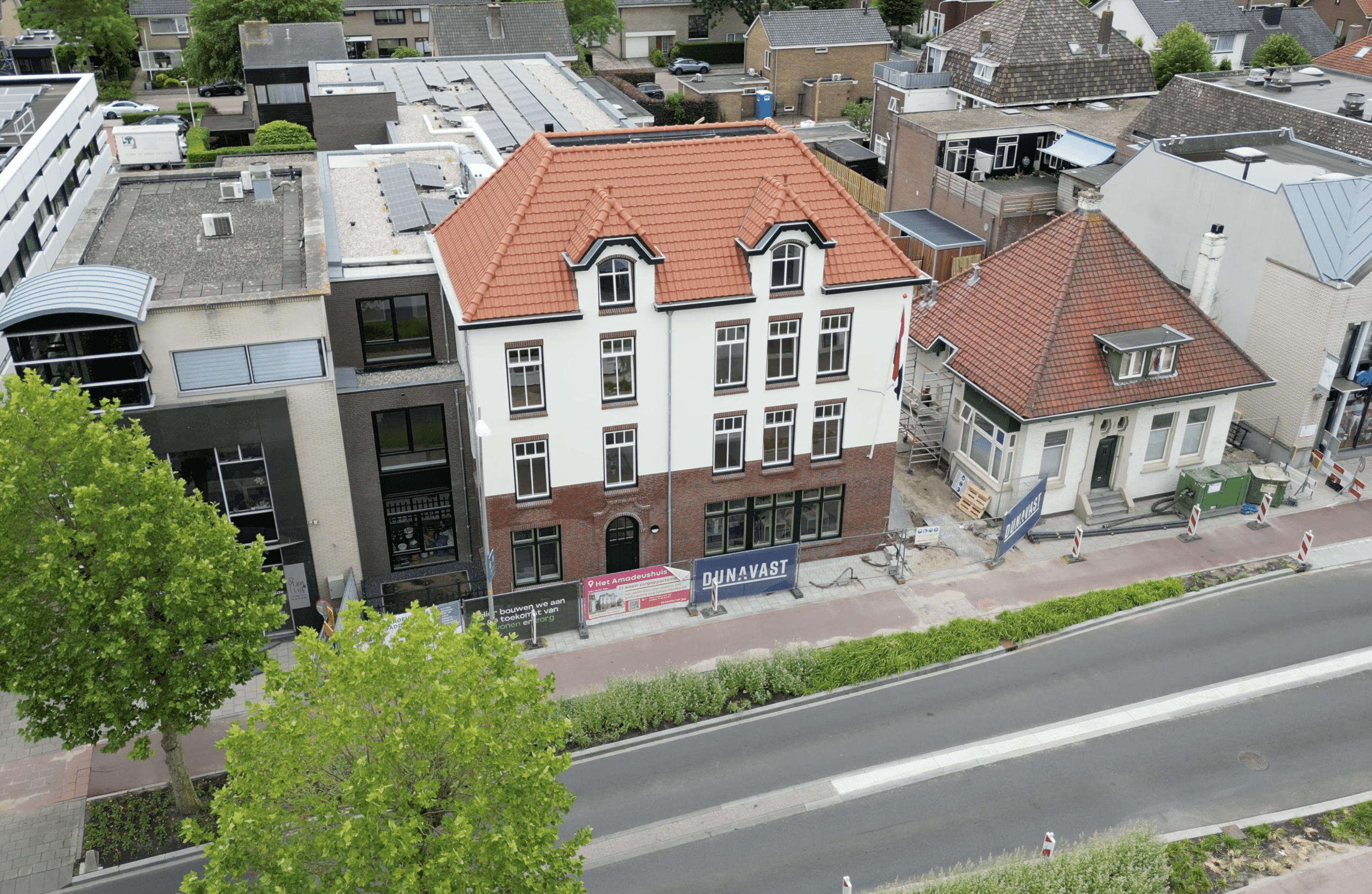 Het Amadeushuis in aanbouw, in de afrondende fase, met steigers rondom het gebouw.