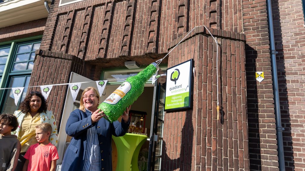 Wethouder Brigitte Leferink deed de opening van de buitenschoolse opvang: ze doopte het gebouw met een ‘champagnefles’ van papier.