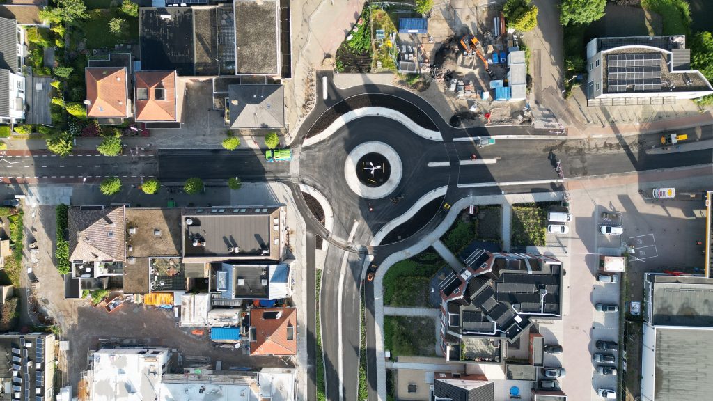 Een luchtfoto van de rotonde aan de passage. Het vernieuwde asfalt is te zien en de nieuwe vorm dat de rotonde heeft gekregen.