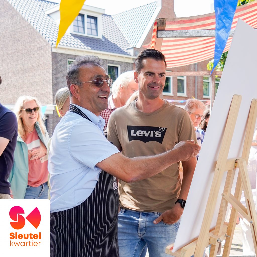 Horecaondernemer en buurtbewoner kijken op een bord naar de plannen
