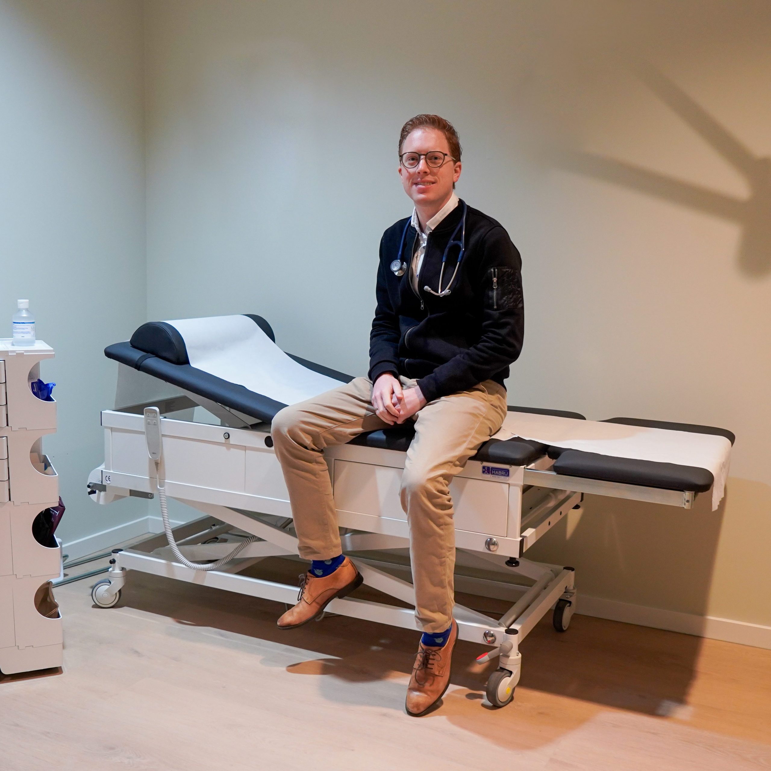 Huisarts Simon Kok op een behandelbank 